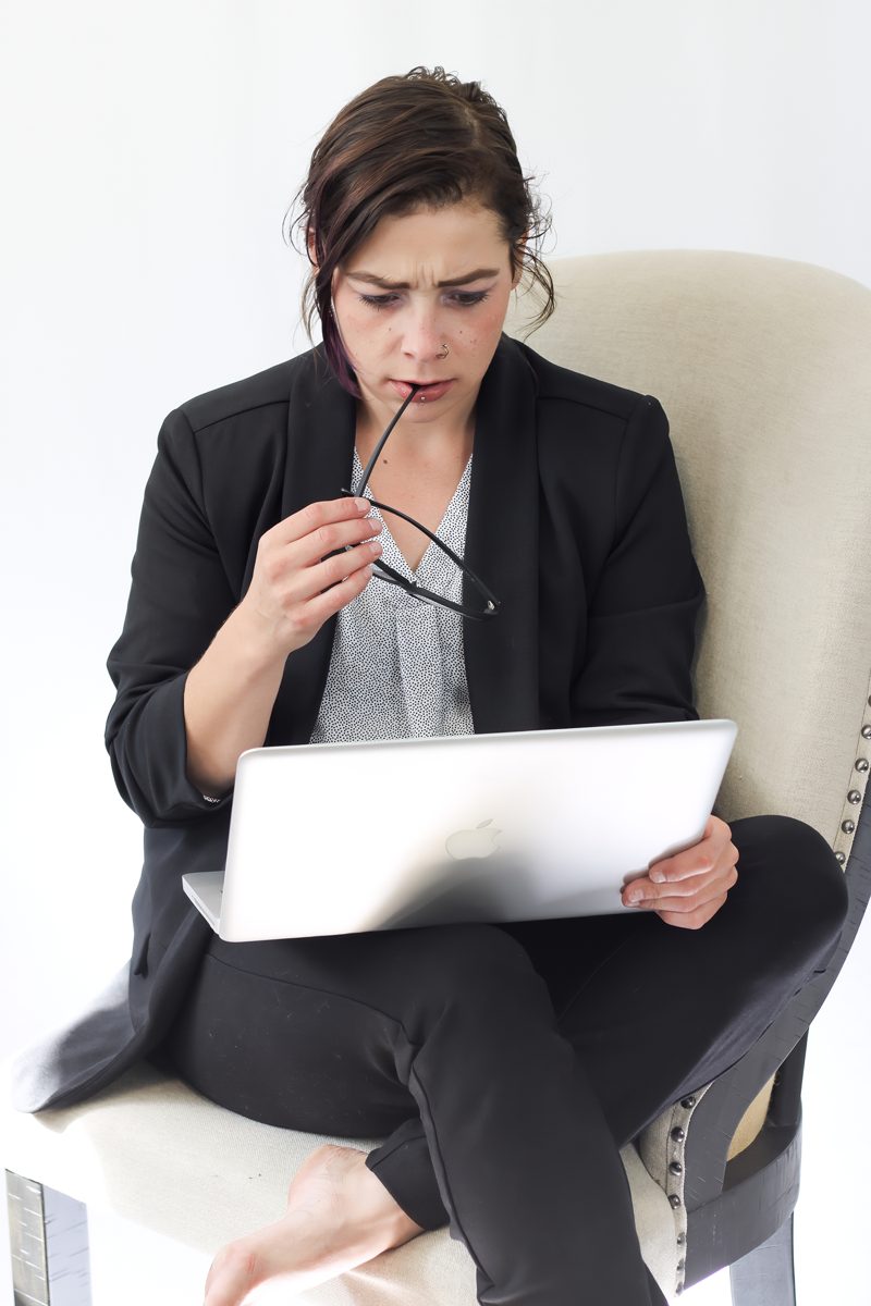 Business owner looking thoughtfully at her laptop